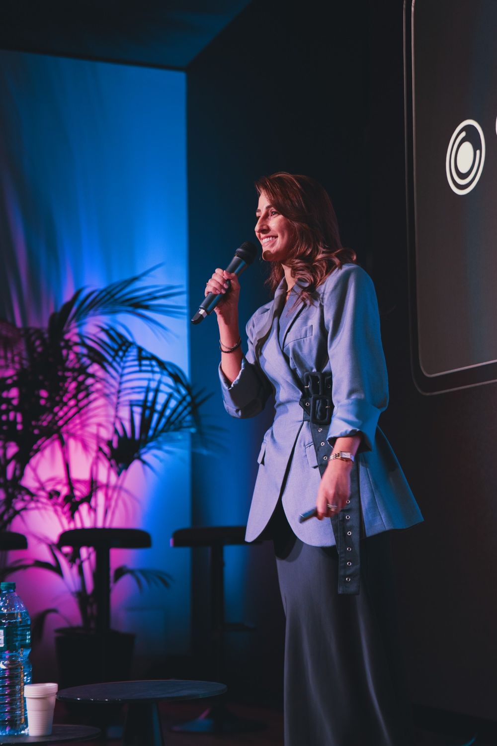 Camilla Brossa smiles at the audience, microphone in hand, on the Torino Tech Map stage at Feat House
